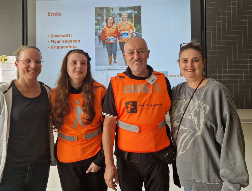 Sensibilisierungsworkshop an einer Sekundarschule in Liestal: Läuferin Salomé, Gabor und die zwei Lehrerinnen vor der Präsentationswand