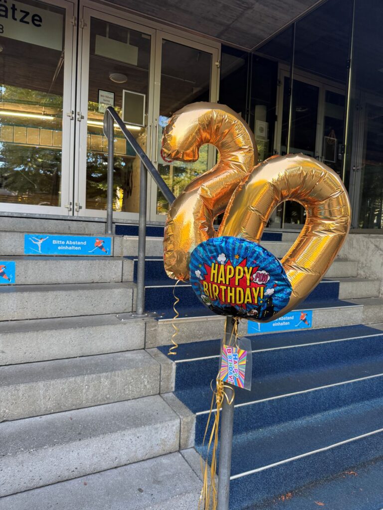20. Jubiläumsfest Blind-Jogging_ Ballons mit der Nummer 20 und enem Happy Birthday Ballon beim Eingang des Restaurants