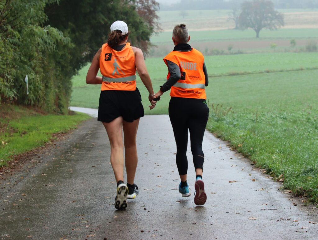 Annabell mit Guide Nadja am Muttenzer Herbstlauf - das Tandem am Joggen von hinten fotografiert