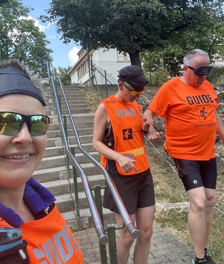Qualitätskontrolle in Liestal, Juli 2026: Selfie von den Teilnehmenden Nadja, Judith und Gregor, bei der Praxisübung auf einer Treppe