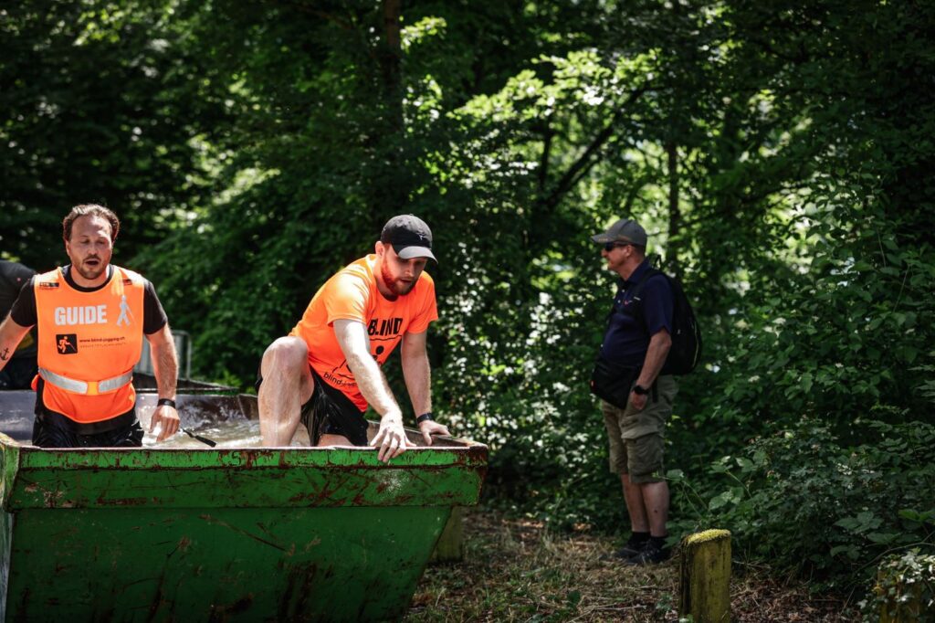 Justin mit Guide Kevin am Obstacle Run in Wettingen, am Überwinden eines Hindernisses