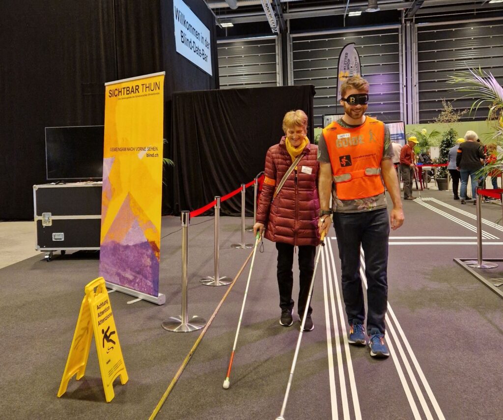 Laufparcours an der Messe Neuland 2024, eine blinde Passantin geführt von einem Guide