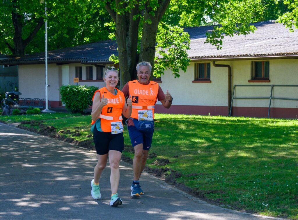 Run4kids 2026: ein Tandem laufend und lachend unterwegs